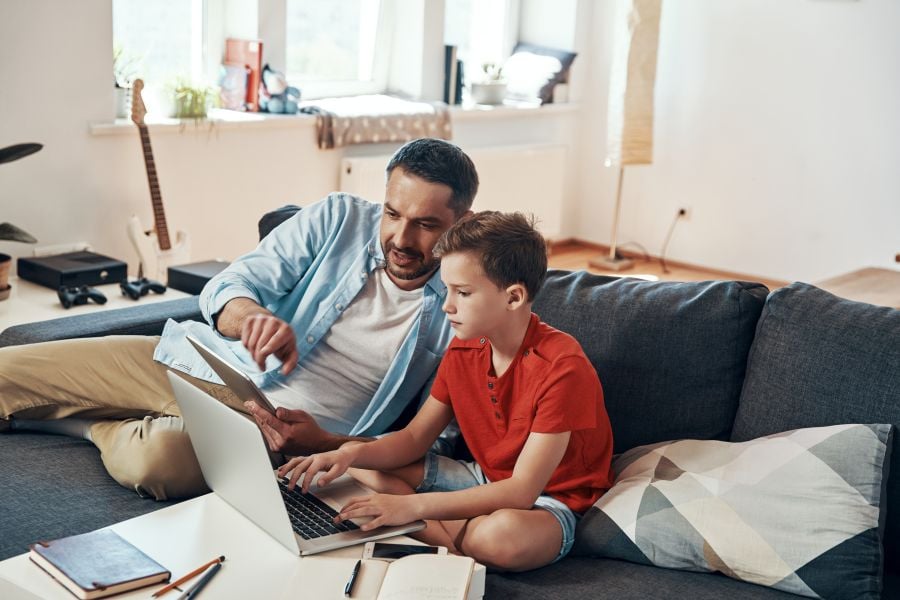 Vater und Sohn sehen sich was auf dem Laptop an