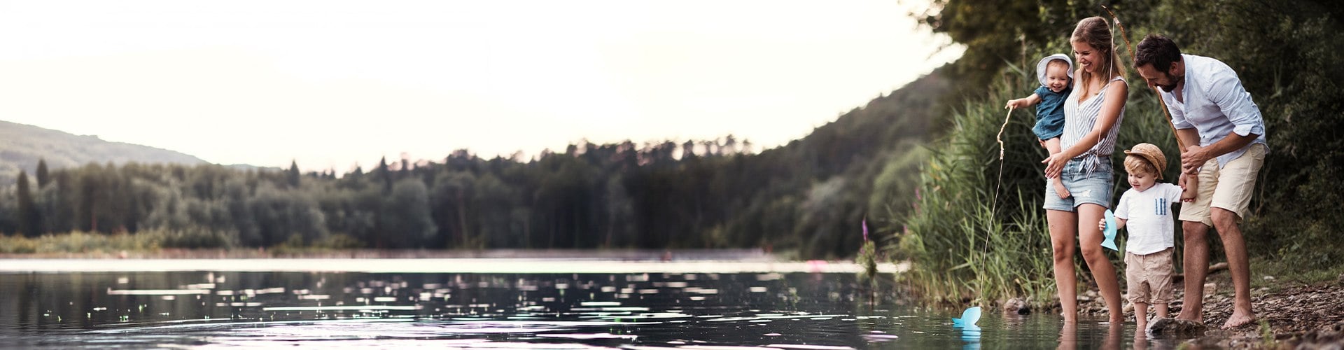 Vierköpfige Familie angelt bei einem Teich