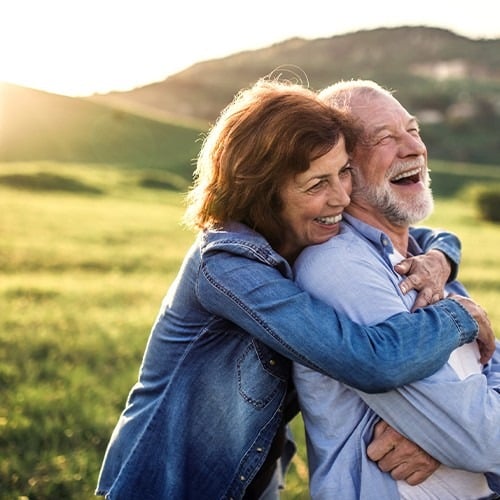 Älteres Ehepaar lächelt und befindet sich in der Natur