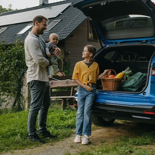 Familie räumt Auto mit Lebensmitteln ein