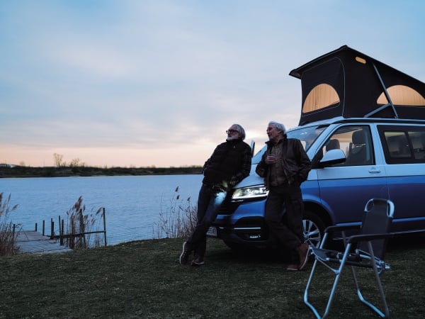 Zwei Männer stehen neben einem Auto