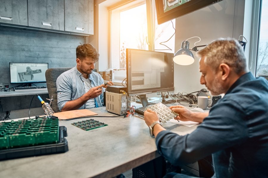 Zwei Arbeitskollegen arbeiten an technischen Umbauarbeiten von PCs