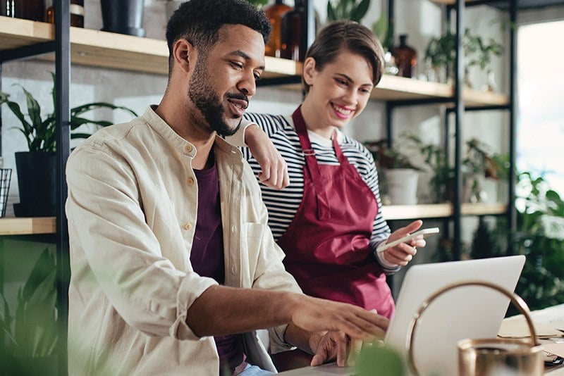 Mann und Frau verkaufen Blümen im Geschäft