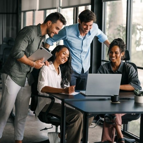 KollegInnen schauen in einen Laptop