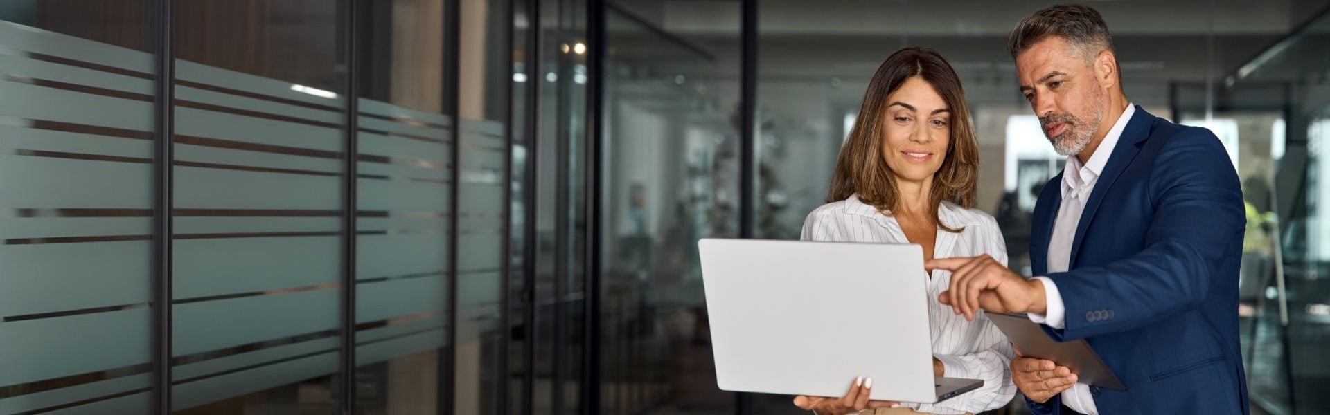 Arbeitskollegin und Geschäftsführer gehen am Laptop etwas durch