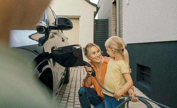 Mutter und Tochter laden e-auto