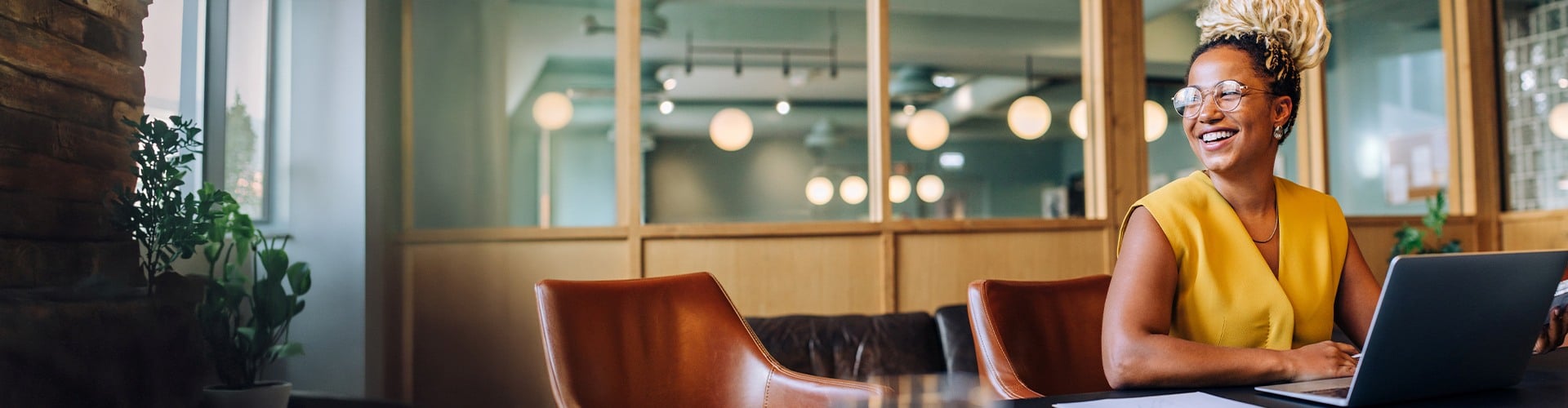 Person hält Tablet und tippt am Laptop