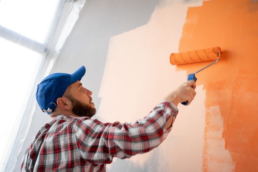 Maler bestreicht Wände einer Wohnung