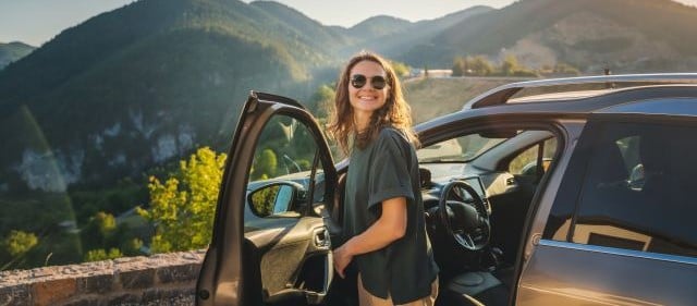 Frau steigt aus einem Auto aus