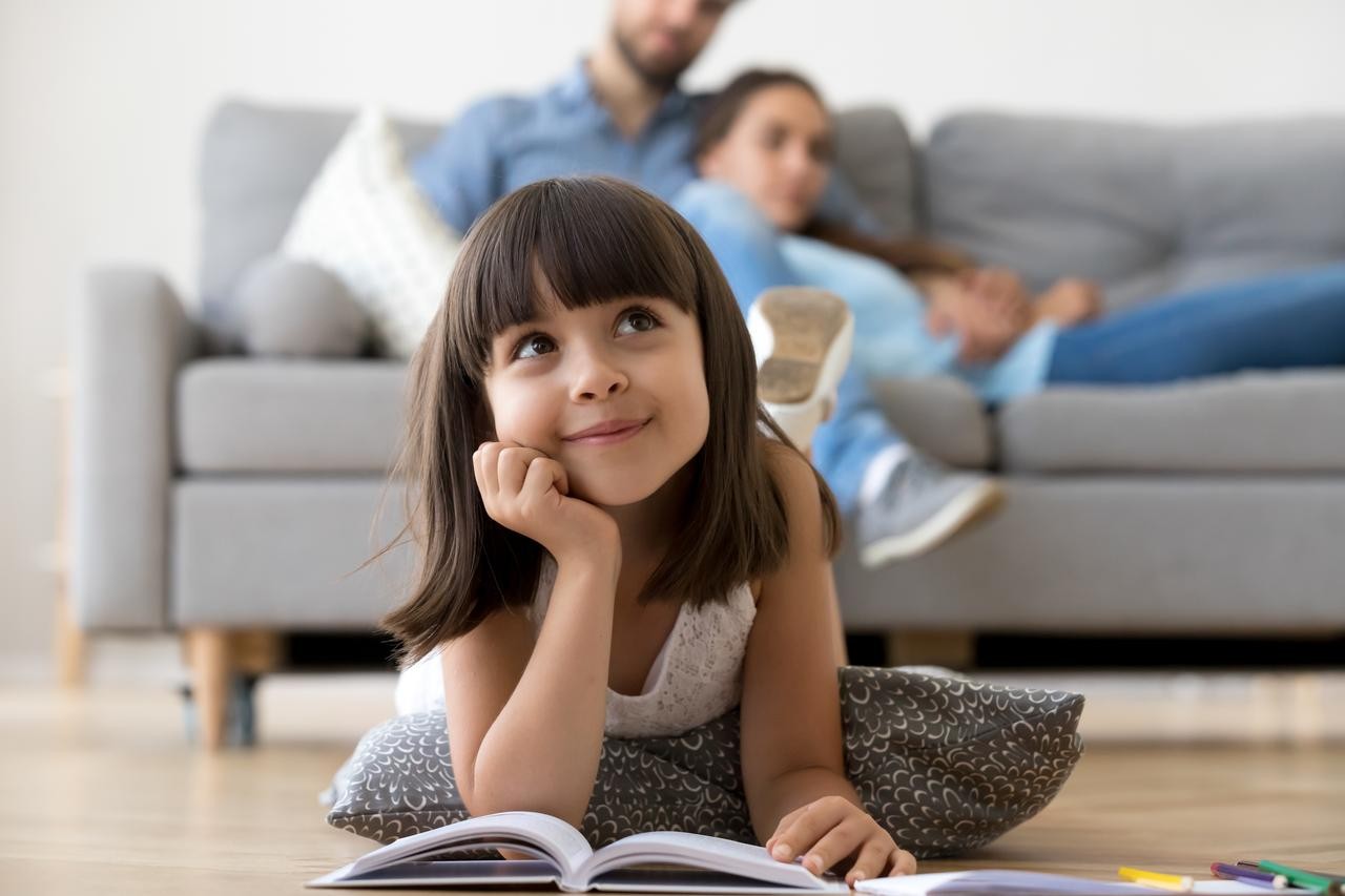 Kind ließt buch auf dem Boden