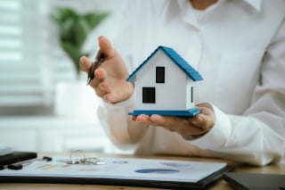 Familie macht Umzug, die Kinder laufen mit den Kartonen in der Hand